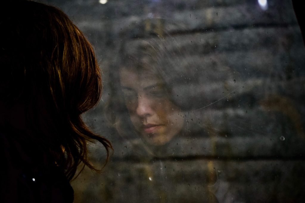 Woman with brown hair looking out window.