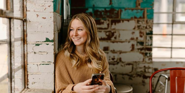 A person smiling while holding a phone

AI-generated content may be incorrect.