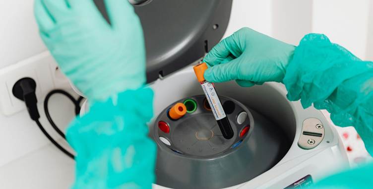 A person holding a tube with a tube in it

AI-generated content may be incorrect.