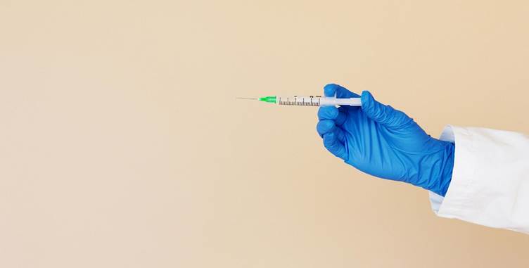 A hand in blue glove holding a syringe
AI-generated content may be incorrect.